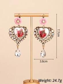 Il s'agit d'une paire de boucles d'oreilles bien conçues. Le style appartient à l'esthétique vintage et romantique, en mélangeant divers éléments : - Conception principale : Pièces en céramique en forme de cœur avec des motifs floraux rouges, ce qui donne une ambiance artistique et romantique. - Éléments décoratifs : les bords des formes de cœur sont garnis de nombreux strass scintillants, ajoutant une touche de luxe.
