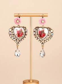 Il s'agit d'une paire de boucles d'oreilles bien conçues. Le style appartient à l'esthétique vintage et romantique, en mélangeant divers éléments : - Conception principale : Pièces en céramique en forme de cœur avec des motifs floraux rouges, ce qui donne une ambiance artistique et romantique. - Éléments décoratifs : les bords des formes de cœur sont garnis de nombreux strass scintillants, ajoutant une touche de luxe.