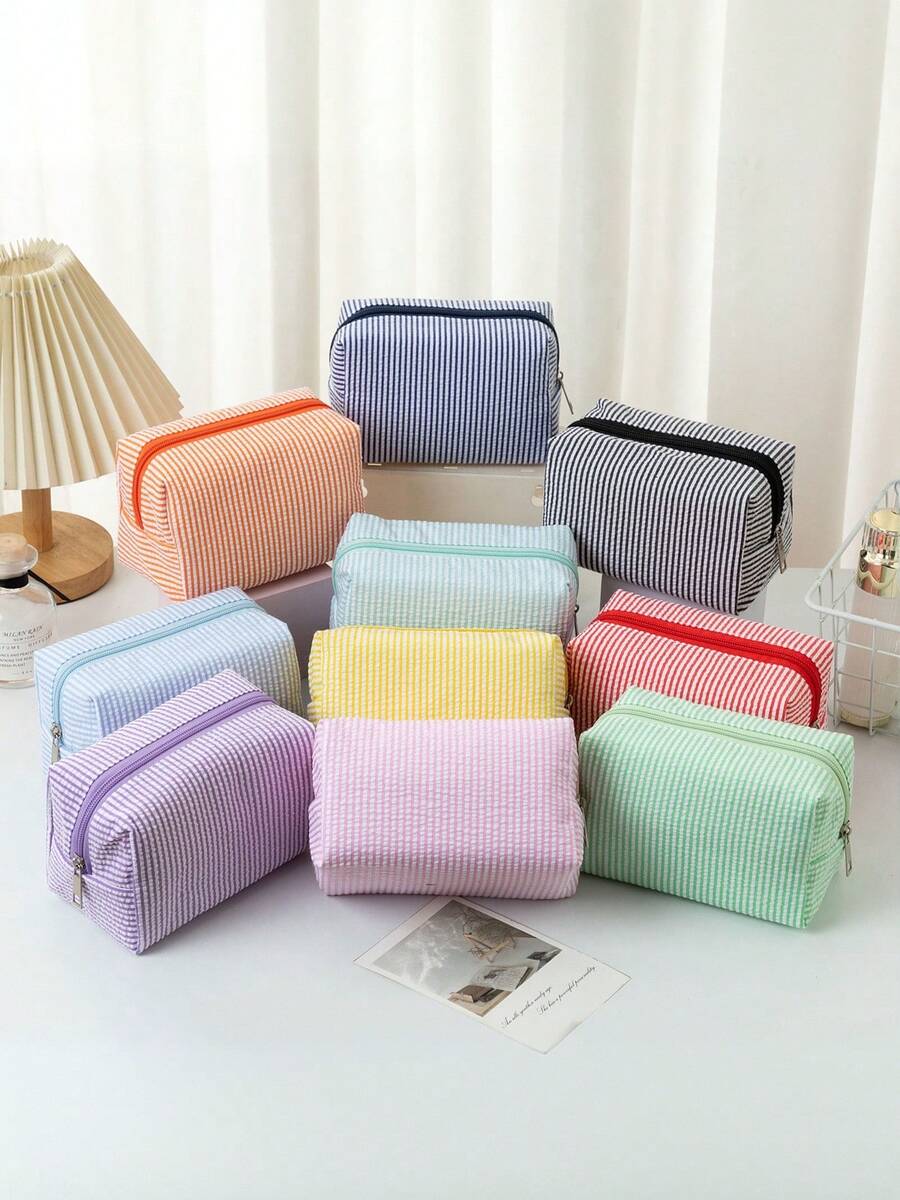 一款泡泡纱化妆包，采用泡泡纱面料制成，超轻超薄，大容量手持洗漱包，刺绣条纹旅行化妆品收纳包