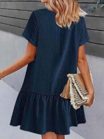 Enfärgad, avslappnad, knappar, volangkant, lös passform, knälång klänning