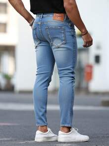 Pantalones jeans ajustados para hombres en denim azul claro con efecto de desgaste y rotura, tela suave y elástica, ideales para estilos casuales y modernos - Azul lavado medio - Ver 3