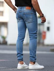 Pantalones jeans ajustados para hombres en denim azul claro con efecto de desgaste y rotura, tela suave y elástica, ideales para estilos casuales y modernos - Azul lavado medio - Ver 3