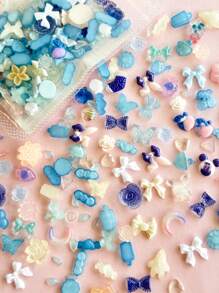 100-120 piezas Conjunto aleatorio con talla grande de una docena de estilos de instalaciones de arte de uñas DIY que incluye moños, conejos, corazones, camelias, rosas, uvas, libélulas, osos, pajaritas, modelos luminosos, modelos de aurora, mariposas, gotas de agua, girasoles, formas de dibujos animados, etc. para decoración de estuches de teléfonos móviles, donde niños y niñas pueden elegir entre una variedad de colores
