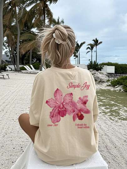Esta camiseta de cuello redondo con estampado de letras y flores coloridas para mujer es de moda y versátil. Camiseta gráfica, disponible en blanco y rosa, adecuada para usar de vacaciones. Casual de verano