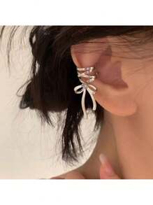Elegant Silver Tone Ribbon Bow Ear Cuff With Sparkling Gem Accent: Chic Non-Piercing Ear Wrap Featuring A Delicate Layered Ribbon Bow Design With A Subtle Sparkling Gemstone Accent, Comfortable And Adjustable Clip-On Style For Non-Pierced Ears, Adds A Touch Of Feminine Charm And Whimsical Elegance To Any Outfit, Perfect For Everyday Wear, Parties, Weddings, Special Occasions, And Expressing Individual Style, Lightweight And Easy To Wear, Makes A Wonderful Gift For Women And Teen Girls Who Love Unique And Non-Pierced Jewelry, Versatile Design Can Be Worn Alone Or Paired With Other Earrings For A Layered Look.