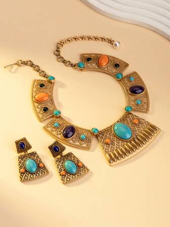 Este es un conjunto de joyas estilo bohemio, que incluye un collar y pendientes. Las joyas están hechas de una base de metal color oro, con incrustaciones de gemas o imitaciones de piedras preciosas turquesa, naranja y moradas. El diseño incorpora elementos geométricos como formas triangulares, que muestran un estilo vintage y lujoso que se adapta a atuendos bohemios e inspirados en vacaciones, agregando un Charm distintivo.