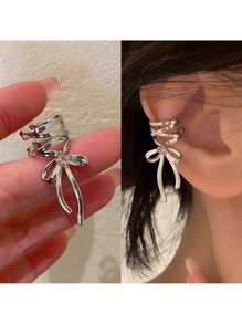 Elegant Silver Tone Ribbon Bow Ear Cuff With Sparkling Gem Accent: Chic Non-Piercing Ear Wrap Featuring A Delicate Layered Ribbon Bow Design With A Subtle Sparkling Gemstone Accent, Comfortable And Adjustable Clip-On Style For Non-Pierced Ears, Adds A Touch Of Feminine Charm And Whimsical Elegance To Any Outfit, Perfect For Everyday Wear, Parties, Weddings, Special Occasions, And Expressing Individual Style, Lightweight And Easy To Wear, Makes A Wonderful Gift For Women And Teen Girls Who Love Unique And Non-Pierced Jewelry, Versatile Design Can Be Worn Alone Or Paired With Other Earrings For A Layered Look.
