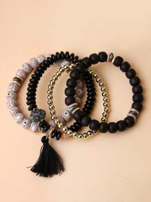 Un conjunto de cuatro brazaletes con borlas y cuentas de estilo bohemio