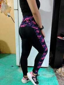 Los mayones son negros con un diseño de manchas moradas y rosas en los laterales, lo que les da un toque moderno y llamativo. Son ajustados y llegan hasta los tobillos, realzando la figura. - Negro rosa - Ver 1