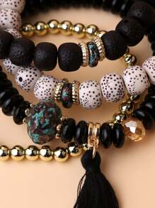 Un conjunto de cuatro brazaletes con borlas y cuentas de estilo bohemio