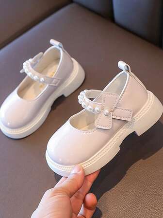 这款女童鞋采用PU材质，饰以珍珠，鞋底防滑耐磨。圆头设计搭配魔术贴搭扣，适合春夏穿着。