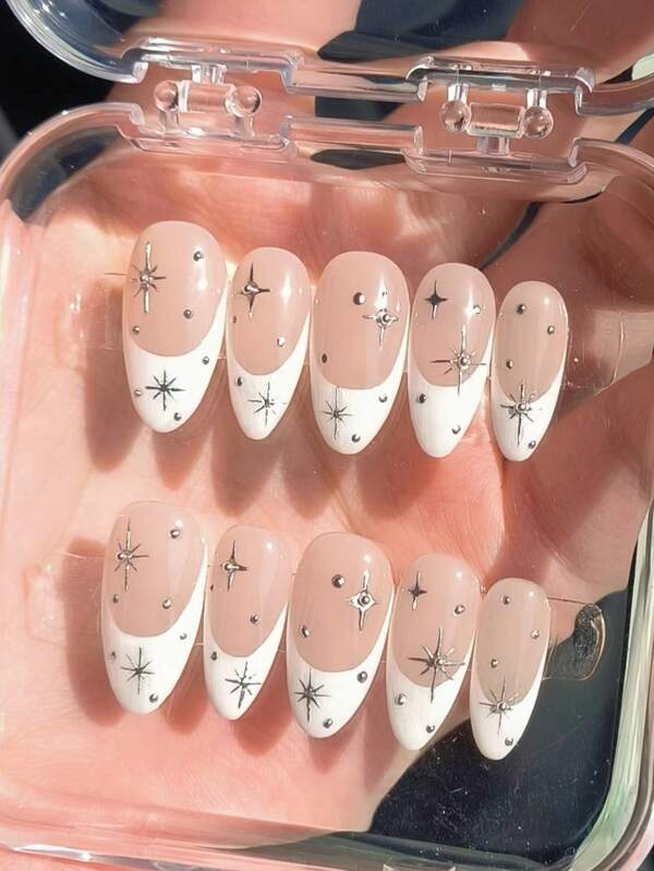 Ce set de 10 pièces de nail art purement artisanal, doux et simple pour fille branchée, comprend une forme d'amande blanche française longue et tridimensionnelle avec une décoration d'étoiles métalliques, agrémentée de petites boules en acier. Il s'agit d'ongles de haute qualité, haut de gamme et durables à porter.