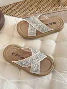Un par de chanclas para niñas de talla grande vendidas/nuevas 2025 con un diseño de tira cruzada en la parte superior y adornadas con una gran cantidad de brillantes rhinestones, presentando un estilo lujoso y de moda. La suela está impresa con el logotipo de la marca. El diseño general es adecuado para que las niñas de 3 a 12 años las usen en salidas diarias, asistir a fiestas y otros eventos. Son unas chanclas para niñas con estilo y brillo, que combinan belleza y comodidad.