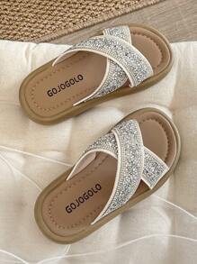 Un par de chanclas para niñas de talla grande vendidas/nuevas 2025 con un diseño de tira cruzada en la parte superior y adornadas con una gran cantidad de brillantes rhinestones, presentando un estilo lujoso y de moda. La suela está impresa con el logotipo de la marca. El diseño general es adecuado para que las niñas de 3 a 12 años las usen en salidas diarias, asistir a fiestas y otros eventos. Son unas chanclas para niñas con estilo y brillo, que combinan belleza y comodidad.
