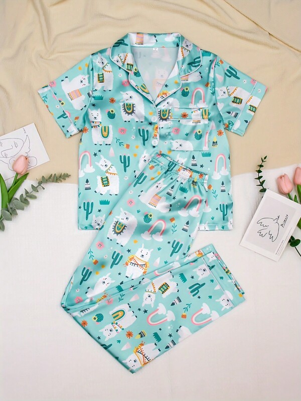 Set de 2 piezas de pijama para niñas con Top de manga corta con estampado de planta tropical y animal en la solapa, y pantalones. Ropa de estar en casa cómoda y casual.
