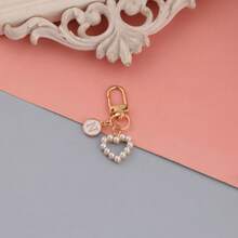 Um pingente de bolsa com pingente circular rosa com letras de A a Z, com um chaveiro de pérola em formato de coração e um estilo elegante e simples. É perfeito para combinar com fantasias de Halloween e para estudantes universitários e do ensino fundamental. Também é um pingente de bolsa, chaveiro de carro, para aniversários, feriados, volta às aulas, ideal para presentear familiares, amigos, namorados, presentes de aniversário, presentes de feriado, presentes de Dia das Mães, presentes de Dia dos Professores.