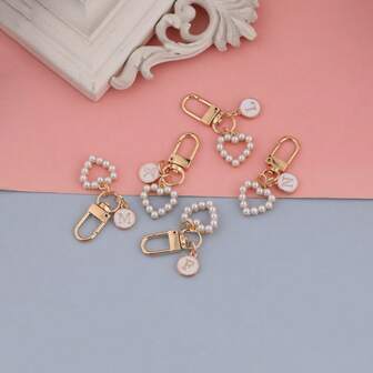 这款包包吊坠采用粉色字母A~Z圆形吊坠设计，搭配心形珍珠钥匙扣，风格时尚简约。适合万圣节服装搭配，也适合大学生和小学生佩戴。它也可以作为包包吊坠、汽车钥匙扣，适合生日、节日、返校季，适合送给家人、朋友、爱人、生日礼物、节日礼物、母亲节礼物、教师节礼物。