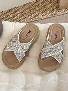 Un par de chanclas para niñas de talla grande vendidas/nuevas 2025 con un diseño de tira cruzada en la parte superior y adornadas con una gran cantidad de brillantes rhinestones, presentando un estilo lujoso y de moda. La suela está impresa con el logotipo de la marca. El diseño general es adecuado para que las niñas de 3 a 12 años las usen en salidas diarias, asistir a fiestas y otros eventos. Son unas chanclas para niñas con estilo y brillo, que combinan belleza y comodidad.
