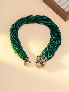 女士项链和手链套装，包含一条项链和一条手链，饰有渐变绿蓝珠子，并以镶嵌蓝色宝石和钻石的精致虎头扣点缀。独特的设计融合了粗犷与迷人的元素，适合搭配极简主义或前卫风格的服装，是派对造型的完美配饰，也是整体造型的焦点。 - 彩色 - 查看 8