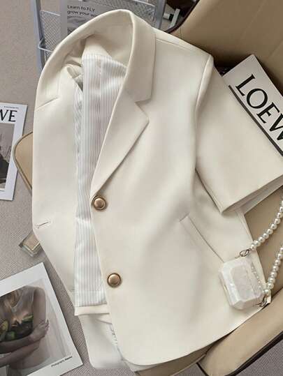 Wiosenno-letnia, cienka, swobodna marynarka damska w stylu "slip". Biała marynarka z krótkim rękawem i złotymi guzikami.