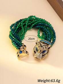 女士项链和手链套装，包含一条项链和一条手链，饰有渐变绿蓝珠子，并以镶嵌蓝色宝石和钻石的精致虎头扣点缀。独特的设计融合了粗犷与迷人的元素，适合搭配极简主义或前卫风格的服装，是派对造型的完美配饰，也是整体造型的焦点。 - 彩色 - 查看 6