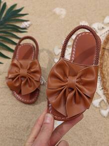 1 Pair Brown Toddler Girls' Flat Sandals, Solid Color PU, Bow Decor Elastic Backstrap, Open Toe, Roman Style Casual Beach Sandals Suitable For 3-15 Years Old Girls, Summer New Arrival