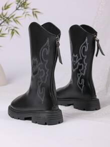 زوج من أفضل إصدارات بوت البنات لعام 2025 الجديدة، مصنوعة من الجلد الأسود في الجزء العلوي مع تصميمات محددة بخيوط بيضاء، أنيقة وأنيقة. تصميم النعل السميك يعزز الراحة والأناقة، مما يجعلها مناسبة للبنات من عمر 3 إلى 12 سنة لارتدائها مع التنانير أو البناطيل في فصل الخريف والشتاء. إنها بوت غربية عصرية متوسطة الارتفاع للبنات.