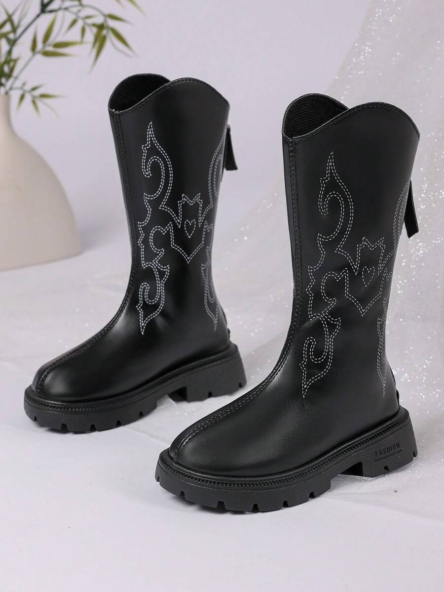 زوج من أفضل إصدارات بوت البنات لعام 2025 الجديدة، مصنوعة من الجلد الأسود في الجزء العلوي مع تصميمات محددة بخيوط بيضاء، أنيقة وأنيقة. تصميم النعل السميك يعزز الراحة والأناقة، مما يجعلها مناسبة للبنات من عمر 3 إلى 12 سنة لارتدائها مع التنانير أو البناطيل في فصل الخريف والشتاء. إنها بوت غربية عصرية متوسطة الارتفاع للبنات.