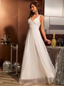 Vestido de novia de corte ceñido con cuello en V, encaje aplicado, sin mangas y con inserciones de malla