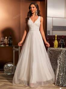 Vestido de novia de corte ceñido con cuello en V, encaje aplicado, sin mangas y con inserciones de malla