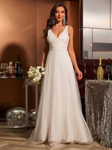 Vestido de novia de corte ceñido con cuello en V, encaje aplicado, sin mangas y con inserciones de malla