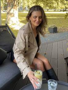 Abrigo corto de mujer tipo trench color caqui con doble botonadura, solapa y manga larga para primavera y otoño