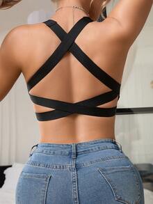 زي رياضي أسود قطعة واحدة مع أشرطة كتف متقاطعة وتصميم خلفي مفتوح، يصقل ويعزز الظهر