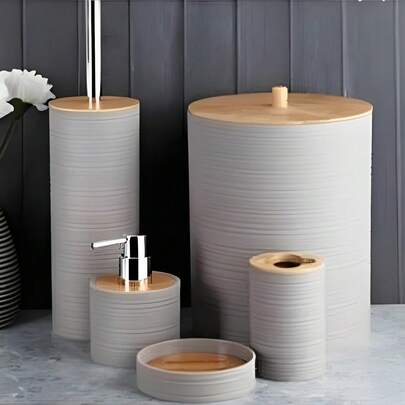 Zestaw łazienkowy z serii Striped, dzięki swojemu unikalnemu i pomysłowemu wzornictwu, stanowi zwieńczenie odnowionej łazienki. Gładkie paski są proste, a zarazem eleganckie, a w połączeniu z ciepłymi, drewnianymi elementami idealnie łączą naturę z modą. Uchwyt na szczoteczki do zębów z drewnianą pokrywą z łatwością pomieści szczoteczki i utrzyma je w suchości i porządku; Elegancka mydelniczka tworzy komfortowe "mieszkanie" dla mydła; Butelka na mydło do rąk zapewnia wygodę i higienę za naciśnięciem jednego przycisku; Pojemny kosz na śmieci z pokrywką z łatwością pomieści drobne śmieci w łazience. Niezależnie od tego, czy jesteś pracownikiem umysłowym w mieście, który ceni sobie jakość życia, czy entuzjastą domowych porządków, który ceni sobie prostą estetykę, ten zestaw produktów łazienkowych sprawi, że każde mycie będzie przyjemnym doświadczeniem i odmieni Twoją łazienkę.