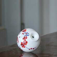 Jarrón de cerámica roja de ciruela: La morada poética de la elegancia oriental en los espacios occidentales. Estos jarrones de cerámica con flores de ciruelo rojo pintadas parecen haber salido directamente de un rollo de pintura oriental. En el contexto de la decoración del hogar europea y americana, rompen el molde convencional. El Body sencillo del jarrón combinado con el vibrante patrón de ciruelo rojo encarna la esencia del espíritu libre de la estética china, al tiempo que satisface la búsqueda occidental de una decoración personalizada. Al usar la cerámica como medio y el ciruelo rojo como motivo, el elegante estilo oriental extiende su presencia poética a los espacios de vida occidentales.