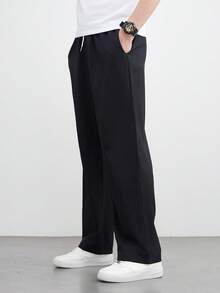 زوج من البناطيل السوداء الرجالية الفضفاضة ذات الساق المستقيمة والواسعة، كاجوال ومتعددة الاستخدامات، قابلة للغسل بالغسالة، بتصميم خصر ربطة