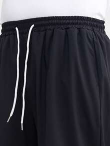 زوج من البناطيل السوداء الرجالية الفضفاضة ذات الساق المستقيمة والواسعة، كاجوال ومتعددة الاستخدامات، قابلة للغسل بالغسالة، بتصميم خصر ربطة