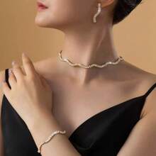 Ensemble de collier, boucles d'oreilles et bracelet à vague brillante de mode. Accessoires élégants en trois pièces pour mariée, mariage et fête