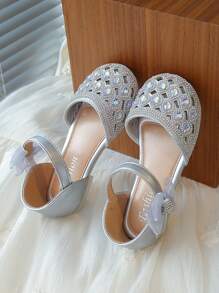 Un par de zapatos planos para niñas de estilo princesa dulce con decoraciones de lazo con diamantes de agua y hebillas para uso en fiestas y días festivos