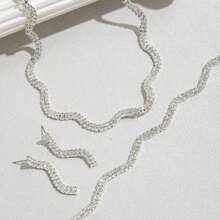 Ensemble de collier, boucles d'oreilles et bracelet à vague brillante de mode. Accessoires élégants en trois pièces pour mariée, mariage et fête