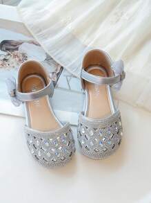 Un par de zapatos planos para niñas de estilo princesa dulce con decoraciones de lazo con diamantes de agua y hebillas para uso en fiestas y días festivos