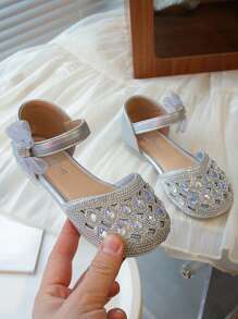 Un par de zapatos planos para niñas de estilo princesa dulce con decoraciones de lazo con diamantes de agua y hebillas para uso en fiestas y días festivos