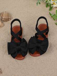 1 par de sandalias planas de unicolor para niñas, con diseño de tiras cruzadas con decoración de moño, y suela suave y cómoda, adecuada para salidas de verano, viajes a la playa y vacaciones de las niñas