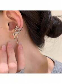 Elegant Silver Tone Ribbon Bow Ear Cuff With Sparkling Gem Accent: Chic Non-Piercing Ear Wrap Featuring A Delicate Layered Ribbon Bow Design With A Subtle Sparkling Gemstone Accent, Comfortable And Adjustable Clip-On Style For Non-Pierced Ears, Adds A Touch Of Feminine Charm And Whimsical Elegance To Any Outfit, Perfect For Everyday Wear, Parties, Weddings, Special Occasions, And Expressing Individual Style, Lightweight And Easy To Wear, Makes A Wonderful Gift For Women And Teen Girls Who Love Unique And Non-Pierced Jewelry, Versatile Design Can Be Worn Alone Or Paired With Other Earrings For A Layered Look.