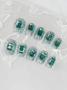 1 ensemble de 10 pièces d'ongles carrés courts et exquis avec de fins paillettes irisées peintes à la main et des pierres précieuses bleu saphir glacé. Cet accessoire d'ongles faux de style minimaliste allonge la longueur des doigts et ajoute une touche de mode à vos ongles.