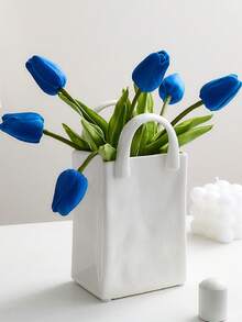 1件独特的白色和金色手提包造型树脂花瓶，这款时尚花瓶配有金属把手，非常适合在咖啡桌、梳妆台上或卧室装饰中展示鲜花，为您的家增添迷人的现代气息。