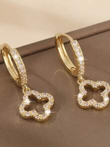 Un par de pendientes de cobre lujosos con circonita, con un diseño floral estelar hueco simple y elegante