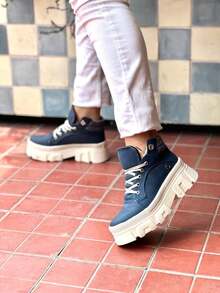 Estos botines para mujer combinan estilo y funcionalidad con una plataforma chunky que aporta altura y comodidad. Diseñados para llegar al tobillo, cuentan con agujetas para un ajuste personalizado. Ideales para un look casual y moderno, son perfectos para combinar con una variedad de atuendos. - Azul - Ver 1