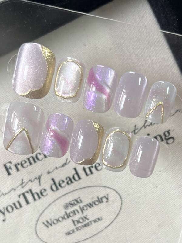 Cet ensemble de nail art comprend 10 ongles carrés courts faits main, présentant un design dégradé violet avec des effets œil de chat, des vibrations d'aurore boréale islandaise, des diamants écrasés et des perles de verre, le tout dégageant un éclat brillant.
