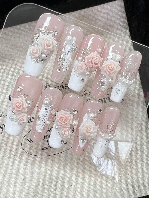 Ce set de nail art comprend 10 ongles longs de forme cercueil faits main, combinant le style français rose avec des accents argentés. Ornés de paillettes, de fine brillance, de camélias roses, de strass et de paillettes scintillantes, il dégage un charme pur et séduisant avec un éclat brillant. Ces ongles à clipser sont amovibles.